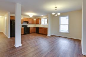 Amherst triplex for rent - an empty living room and kitchen with wood flooring
