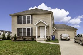 Amherst triplex for rent - a tan house with a car parked in front of it