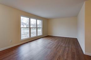 Amherst triplex for rent - an empty living room with wood floors and a large window