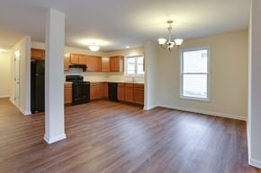 Amherst triplex for rent - an empty living room and kitchen with wood flooring