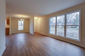 Amherst triplex for rent - an empty living room with large windows and wood floors