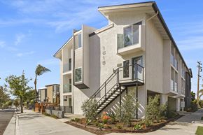 Seal Beach apartment for rent - a row of town homes with stairs and balconies on a sidewalk