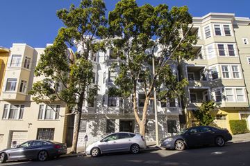 San Francisco apartment for rent - A tree in front of a building with cars parked in front of it.