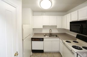 Indianapolis apartment for rent - a kitchen with white cabinets and black appliances and a sink