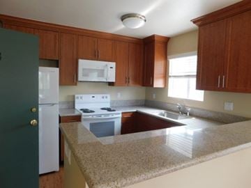 San Diego apartment for rent - A kitchen with a white stove and a green door.