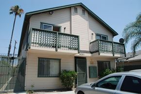 San Diego apartment for rent - A two-story house with a balcony and a car parked in front.