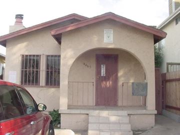 San Diego apartment for rent - A small house with a red door and a sign on the wall.