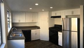 Reseda apartment for rent - a kitchen with white cabinets and a stainless steel refrigerator