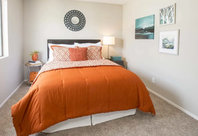 Reseda apartment for rent - a bedroom with an orange comforter and orange pillows