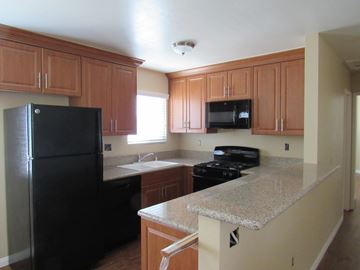 San Diego apartment for rent - a kitchen with black appliances and granite counter tops