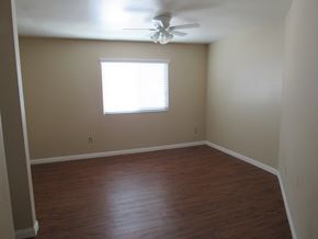 San Diego apartment for rent - an empty room with wooden floors and a ceiling fan