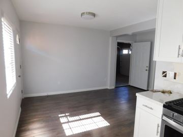 San Diego apartment for rent - A kitchen with white cabinets and a black stove top oven.