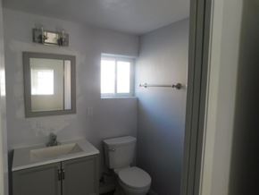 San Diego apartment for rent - A bathroom with a toilet, sink, and mirror.