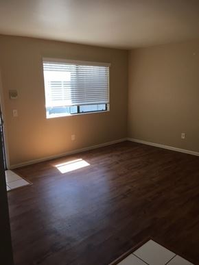 San Diego apartment for rent - A room with a window and wooden floors.