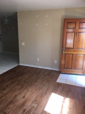 San Diego apartment for rent - A room with a wooden floor and a brown door.