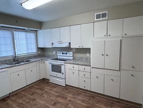 Omaha apartment for rent - A kitchen with white cabinets and a wooden floor.