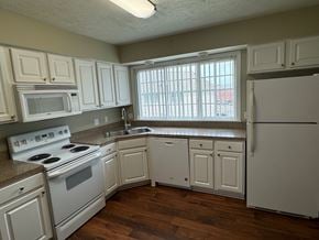 Omaha apartment for rent - A kitchen with white appliances and cabinets.