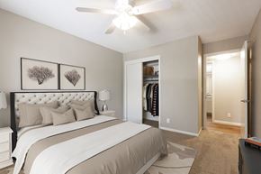 Omaha apartment for rent - a bedroom with a large bed and a ceiling fan