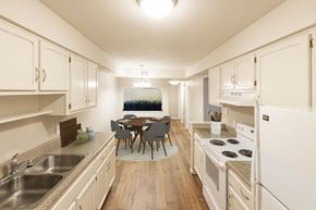 Omaha apartment for rent - a kitchen and dining room with white cabinets and a table and chairs