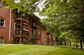 Omaha apartment for rent - a row of brick apartment buildings with grass and trees