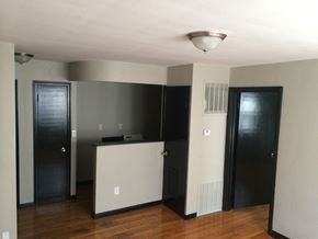 St. Louis apartment for rent - an empty living room with a kitchen and two doors