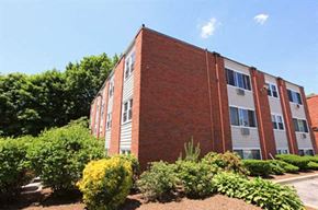 Riverside apartment for rent - a brick building with a garden in front of it