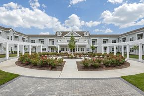 Cranbury apartment for rent - a large white building with a garden in front of it