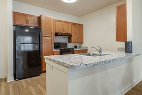 Cranbury apartment for rent - a kitchen with a granite counter top and a black refrigerator