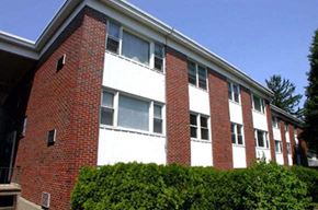 Cranston apartment for rent - a red brick building with bushes in front of it