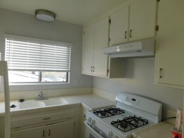 San Diego apartment for rent - a kitchen with a stove and a sink and a window