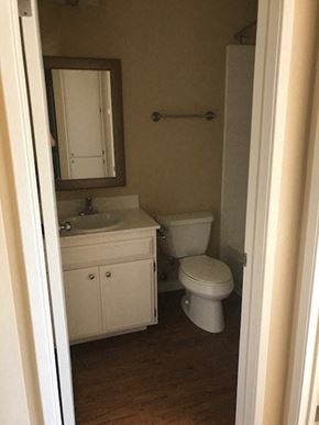 San Diego apartment for rent - A white toilet sits in a bathroom next to a sink and a mirror.