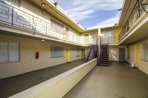 San Francisco apartment for rent - A long hallway with a staircase and a fire extinguisher.