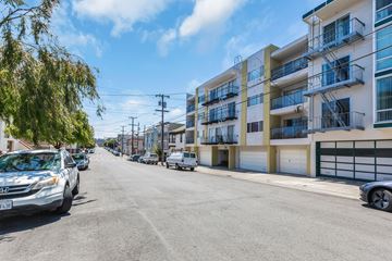 San Francisco apartment for rent - a street with buildings on either side and cars parked on