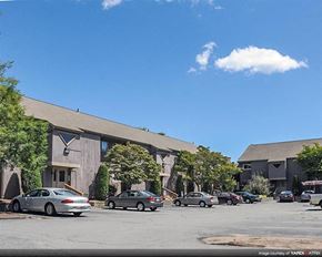 Warwick apartment for rent - a parking lot with cars in front of a building