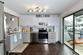 Atlanta apartment for rent - A modern kitchen with white cabinets and stainless steel appliances.