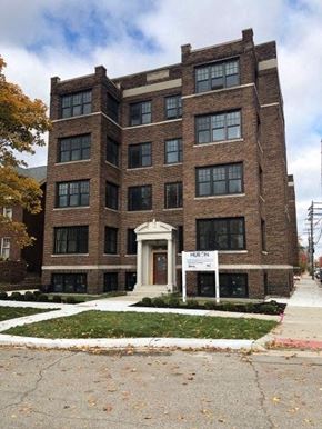 Detroit apartment for rent - a large brick building with a sign in front of it