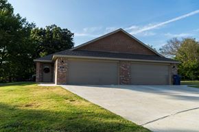 Gentry apartment for rent - a house with a driveway and a garage door