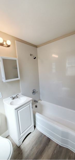 Sacramento apartment for rent - A white bathroom with a white sink and a white tub.