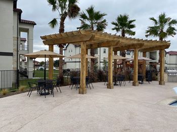 Outdoor dining pergola with seating and umbrellas