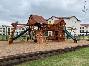 Wooden playground structure with slides and climbing features