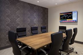 Chicago apartment for rent - A conference room with a large table and chairs and a TV screen displaying a stock market chart.