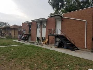 Salt Lake City apartment for rent - A brick building with a white door and a black staircase.