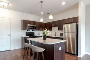 Aliquippa apartment for rent - a kitchen with stainless steel appliances and a island with chairs