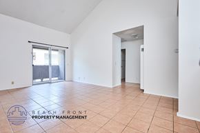 Long Beach apartment for rent - A spacious room with a logo for Beach Front Property Management on the floor.