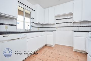 Long Beach apartment for rent - A kitchen with white cabinets and a tile floor.