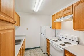 Gwynn Oak apartment for rent - A kitchen with wooden cabinets and white appliances.