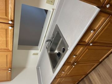 Gwynn Oak apartment for rent - A kitchen with wooden cabinets and a stainless steel sink.