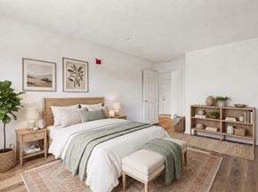 Gwynn Oak apartment for rent - A bedroom with a large bed and a bench.