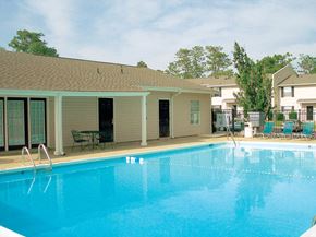 Mobile apartment for rent - pool and lounge chairs behind leasing center at Autumn Chase