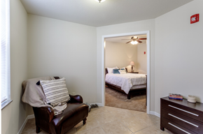 Lawrence apartment for rent - a living room with a chair and a bedroom with a bed